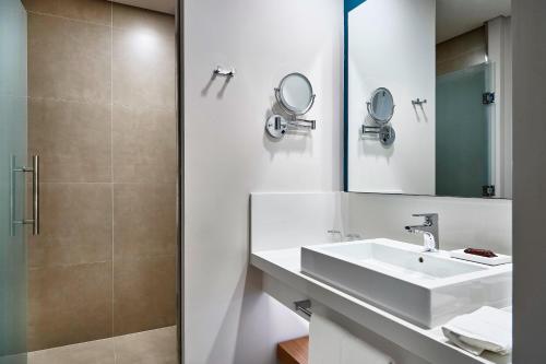 a bathroom with a sink and a mirror at Sheraton Santos Hotel in Santos