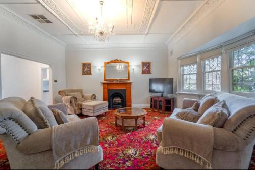 a living room with two couches and a fireplace at Cambridge House, Bendigo in Bendigo