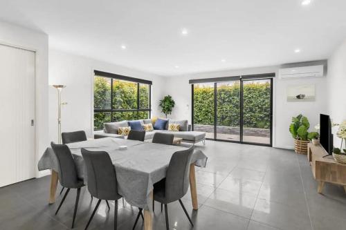 a dining room with a table and a couch at Seaside Retreat, St Leonards in Saint Leonards