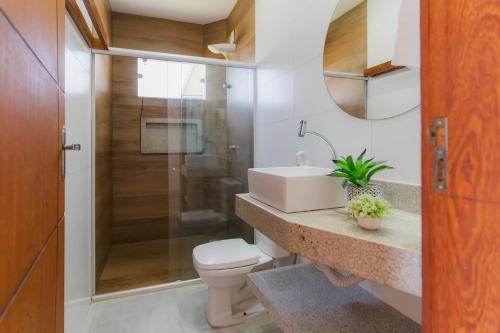 a bathroom with a toilet and a sink and a shower at Shaqat Barra Flat in Barra Grande