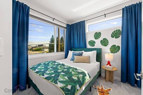 a bedroom with a bed and a window with blue curtains at Urban Jungle Getaway, AirCon, 10min to DT & WEM! in Edmonton