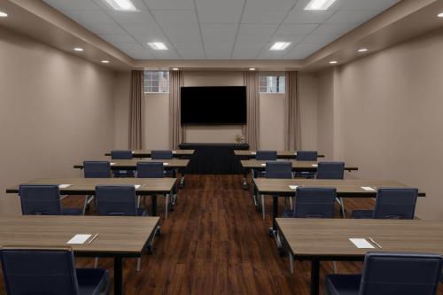 an empty classroom with tables and chairs and a screen at Residence Inn by Marriott Durham Duke University Medical Center Area in Durham