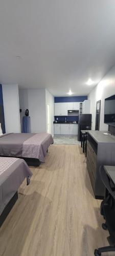 a room with two beds and a desk and a kitchen at Platinum Inn 99 and Morton Ranch in Katy