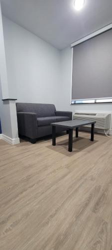 a living room with a black couch and a screen at Platinum Inn 99 and Morton Ranch in Katy