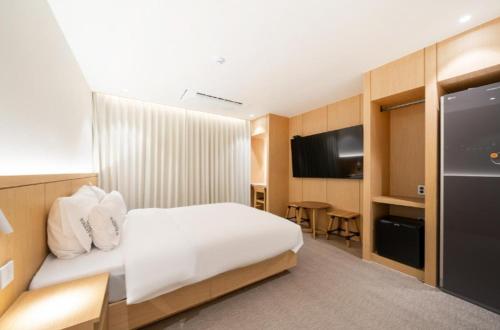 a hotel room with a bed and a television at H avenue Hotel Jeonju Deokjin in Jeonju