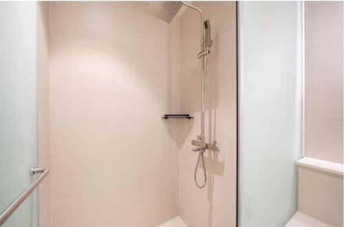 a shower with a glass door in a bathroom at H avenue Hotel Jeonju Deokjin in Jeonju