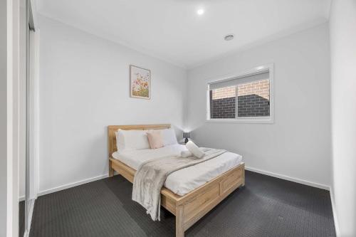 a bedroom with a bed with white walls and a window at Modern Family Home in Lucas with Free WiFi in Windermere
