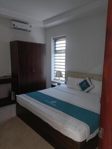a bedroom with a large bed with a window at Bảo Sơn Hotel Hạ Long in Ha Long