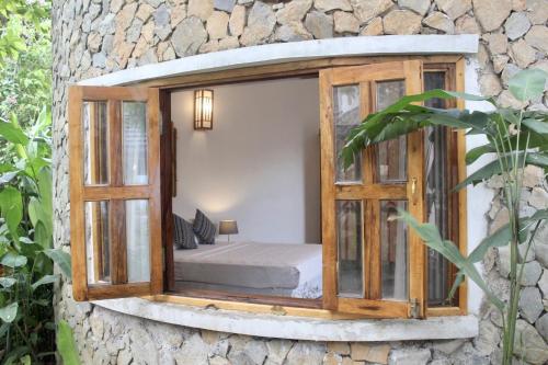 a room with a bed in a stone wall at Bakhan Village Resort in Mai Chau