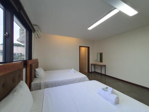 a hotel room with two beds and a window at Koregon Pool Villas in Fort Stotsenburg