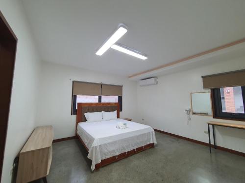 a bedroom with a bed and a flat screen tv at Koregon Pool Villas in Fort Stotsenburg