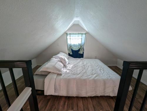 a bedroom with a white bed with a window at Willamette Cottage in Salem
