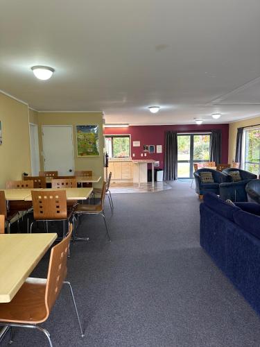a waiting room with tables and couches and chairs at Franz Josef TOP 10 Holiday Park in Franz Josef