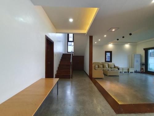 a living room with a couch and a stair case at Koregon Pool Villas in Fort Stotsenburg