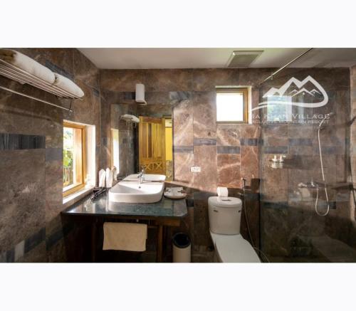 a bathroom with a sink and a toilet at Bakhan Village Resort in Mai Chau