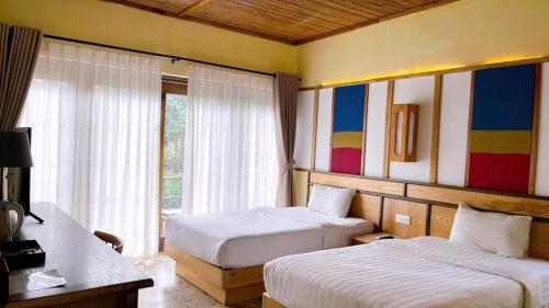 a hotel room with two beds and a window at Bakhan Village Resort in Mai Chau