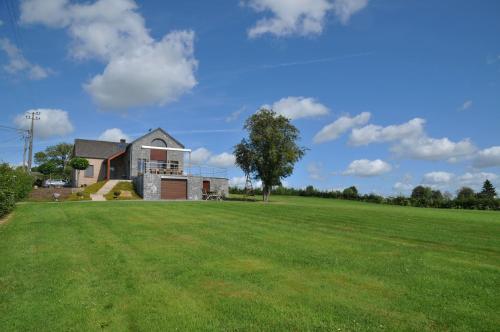 a house in a field with a large yard at La Coline in Somme-Leuze