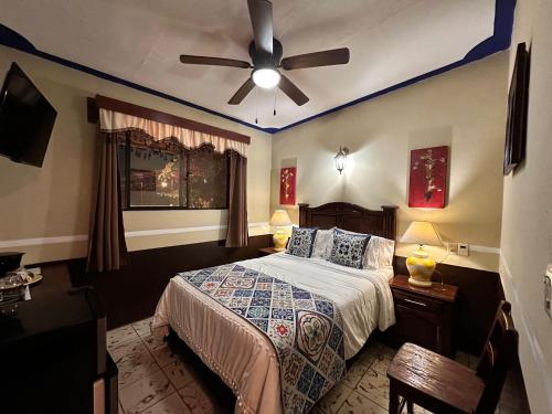 a bedroom with a bed with a ceiling fan at Copa de Oro Hotel Boutique in Mascota