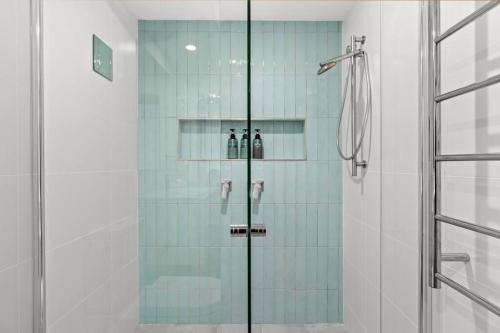 a shower with a glass door in a bathroom at Pacific Breeze in Caves Beach