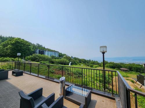 a balcony with two blue chairs and a railing at Iwanai Kogen Hotel in Iwanai