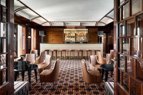 a room with chairs and tables and a bar at Casa Cipriani Milano in Milan