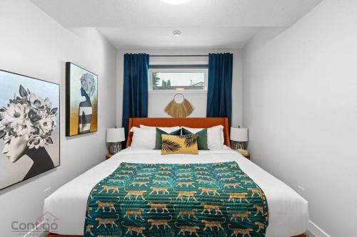 a bedroom with a large bed with blue curtains at The Den, Centrally Located Suite, King Bed, WiFi! in Edmonton