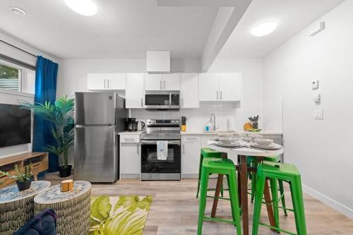 a kitchen with green stools in a white kitchen at The Den, Centrally Located Suite, King Bed, WiFi! in Edmonton