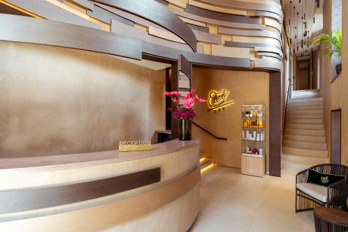 a lobby of a hotel with a counter and flowers at Casa Cipriani Milano in Milan
