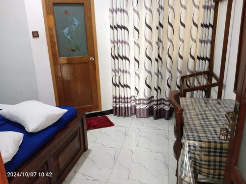 a room with a bed and a door with a curtain at 240 - Two forty in Bandarawela