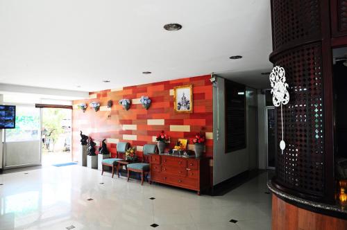 - un salon avec un mur rouge et blanc dans l'établissement Choktawee Smile, à Chiang Mai