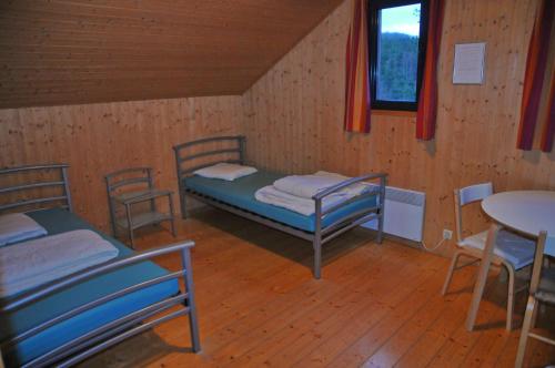 Zimmer mit 2 Betten, einem Tisch und Stühlen in der Unterkunft Jardins de Ourthe 16 in Houffalize