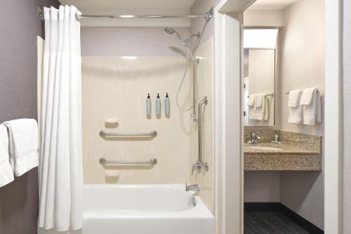 a bathroom with a shower and a white tub at Courtyard Florence South Carolina in Florence