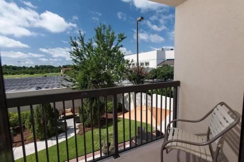a balcony with a bench and a parking lot at Courtyard Florence South Carolina in Florence