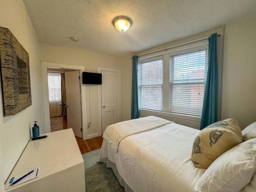 a bedroom with a bed and a large window at Mile To Longwood Medical, Renovated, Pub Trans in Brookline