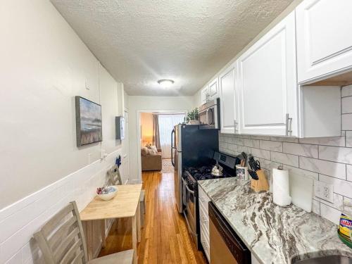 a kitchen with a counter and a stove top oven at Mile To Longwood Medical, Renovated, Pub Trans in Brookline