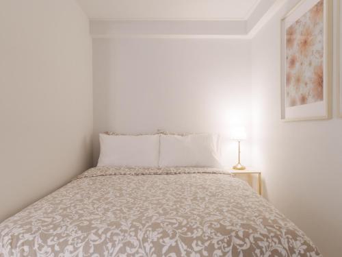 a white bedroom with a bed with a blanket at SeogyoHueStay in Seoul