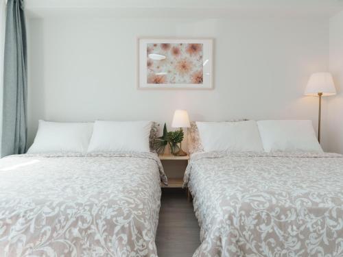 a bedroom with two beds and a picture on the wall at SeogyoHueStay in Seoul