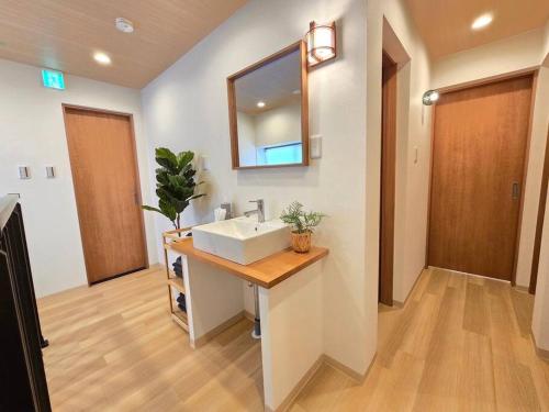 a bathroom with a sink and a mirror at Harukazesou Tengachaya 160平米一戸建貸切 最大18名様 大浴場 駐車場3台 ウッドデッキ 電動自転車付 in Osaka