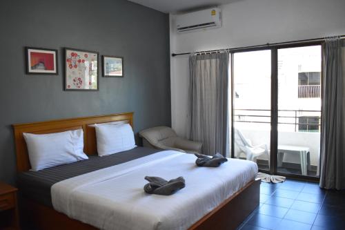 a bedroom with a bed with two shoes on it at Sala Bua Room in Karon Beach