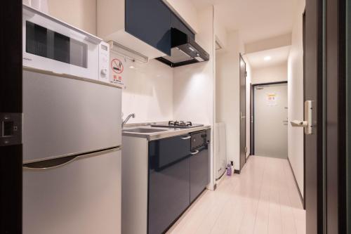 a small kitchen with a sink and a stove at Asakusa Good Place Unmanned Hotel in Tokyo