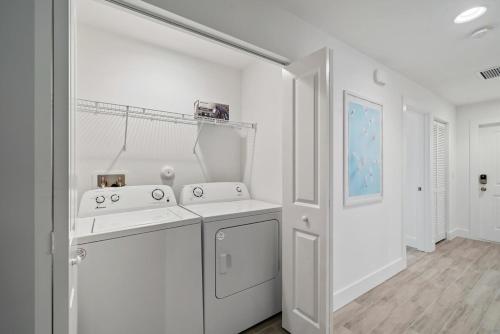 a white kitchen with two sinks and a dishwasher at New! Few Minutes To Downtown, 10 To The Beach! in West Palm Beach