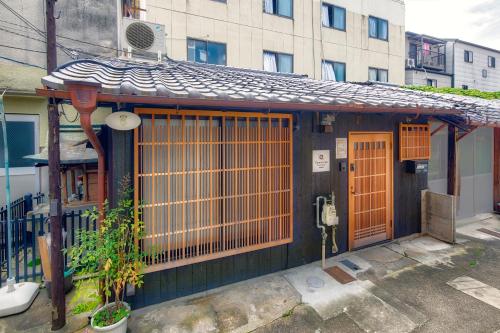 a small house with a gate and a building at Connect inn Kyoto-Gojo in Kyoto