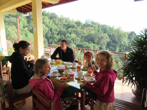 a group of people sitting around a table eating food at Nature Walk Resort in Kandy