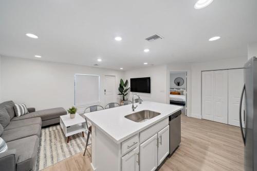 a kitchen and living room with a sink and a couch at New! Few minutes to Downtown, 10 to the Beach! in West Palm Beach