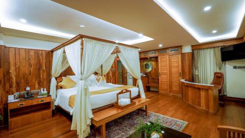 a bedroom with a canopy bed in a room at Chandys Drizzle Drops - Munnar Top Station in Munnar