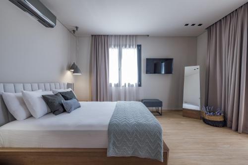 a bedroom with a large bed and a television at El Mar Naxos in Naxos Chora