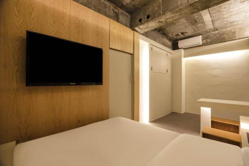 a bedroom with a bed and a tv on a wall at ADO hotel in Seoul