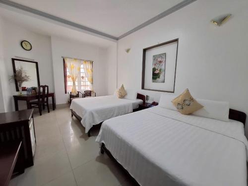 a hotel room with two beds and a table and chairs at Du Hung 2 Hotel in Ha Tien
