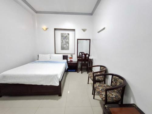 a bedroom with a bed and a table and chairs at Du Hung 2 Hotel in Ha Tien