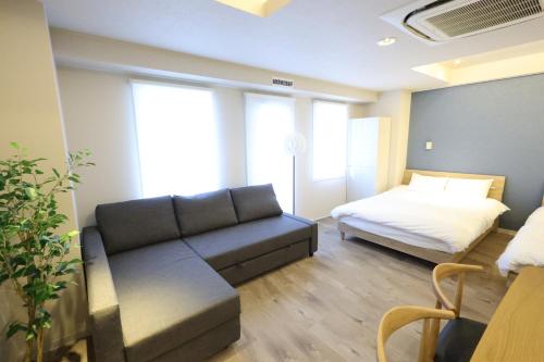 a living room with a couch and a bed at RIVER CENTRAL HIROSHIMA in Hiroshima